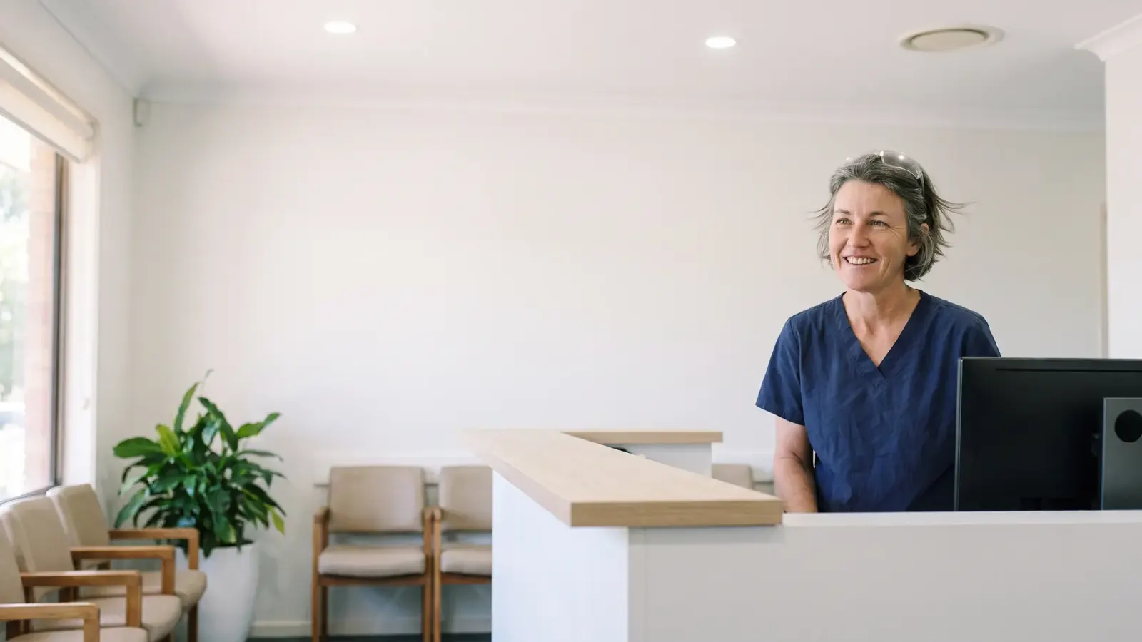 Jo at the front desk of Little Chip Dental, phone beside her